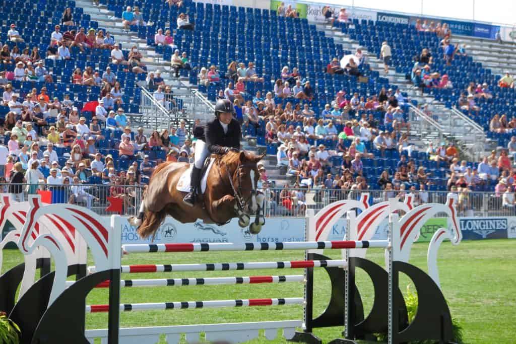 Beezie Madden soars over an oxer jump in the Grand Prix ring at the Hampton Classic. Photo by: Equestrianstylist.com